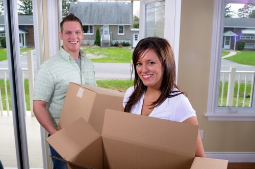 Local movers carrying furniture through a Maryland townhouse entrance